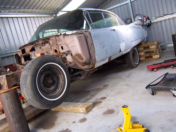 Putting Cadillac in the air for restoration. notice the wood holding up the rear end.