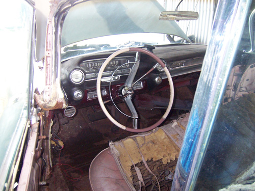 Inside a 1959 Cadillac before being restored, seat torn steering wheel broken