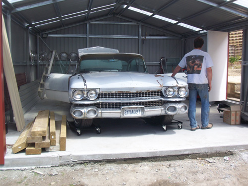 Cadillac on dollys in the garage.