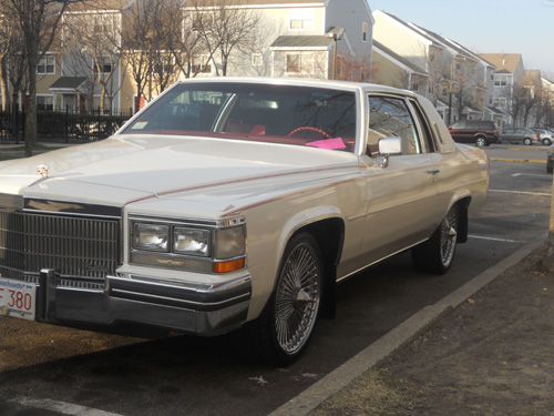 White Cadillac with good looking rims parked at a curb