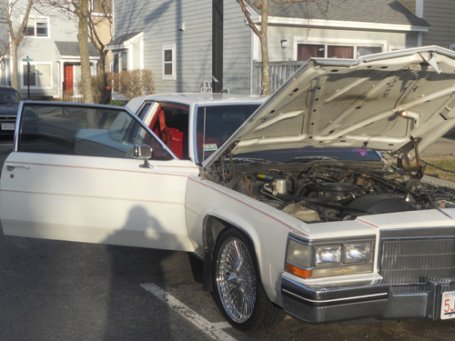 white cadillac with hood and passenger side door open