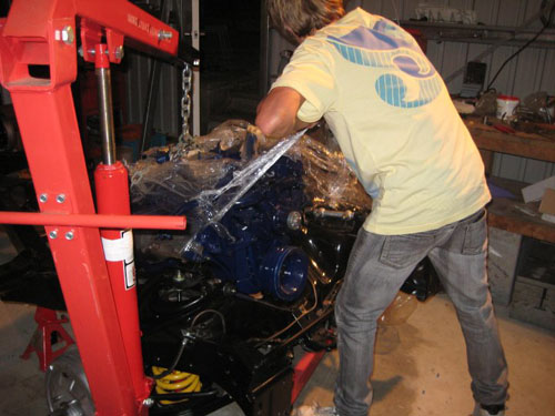 blair ripping the plastic off the new Cadillac engine as he installs it in the car.