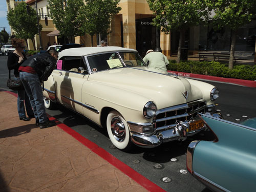 White Cadillac with people looking in the windows