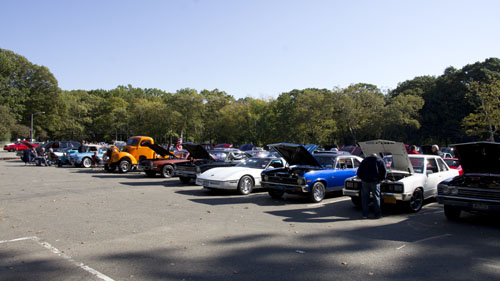 Corvettes, novas and other muscle cars at a car show in nyc.