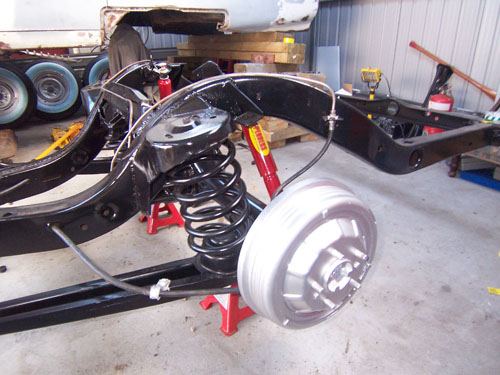 1959 Cadillac on jack stands with coil springs exposed.