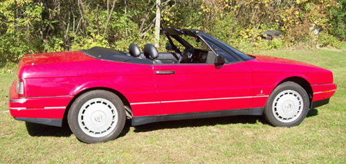 red Cadillac Allante parked near trees