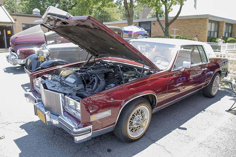 red cadillac with hood open
